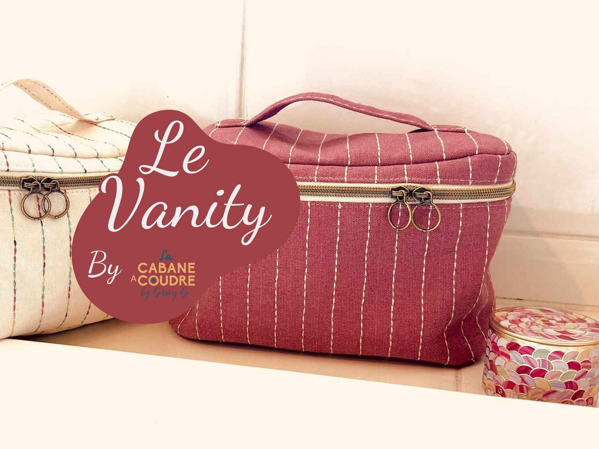 Vanity cousu en tissu matelassé avec fermeture zippée et poignée, posé sur une table. Modèle présenté pour apprendre à coudre un vanity facilement, par La Cabane à Coudre.